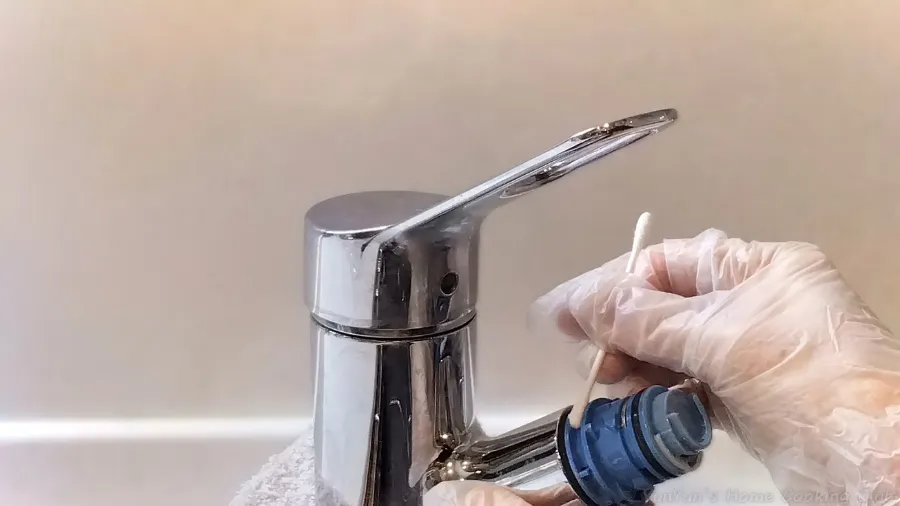 綿棒を使って、水栓内部のカートリッジ接続箇所を掃除している様子