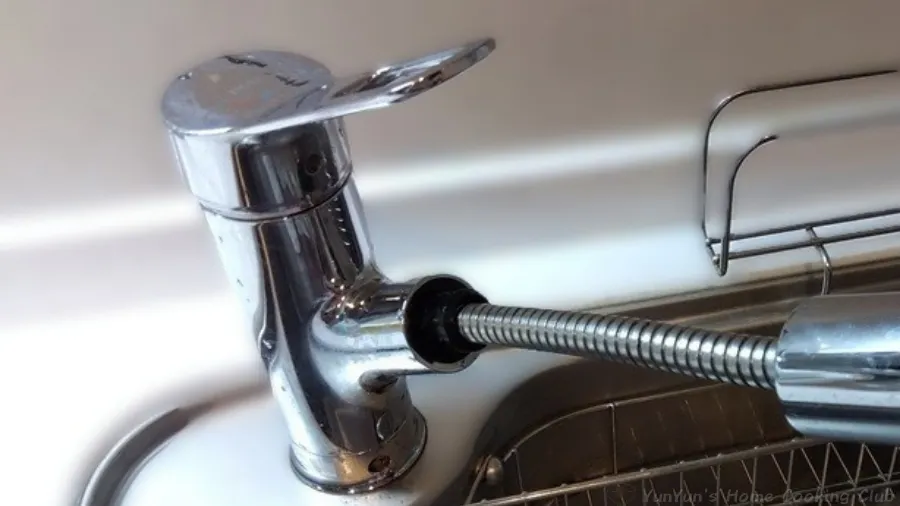 交換後にハンドシャワーのホースを引き出し、スムーズに動くか確認する様子