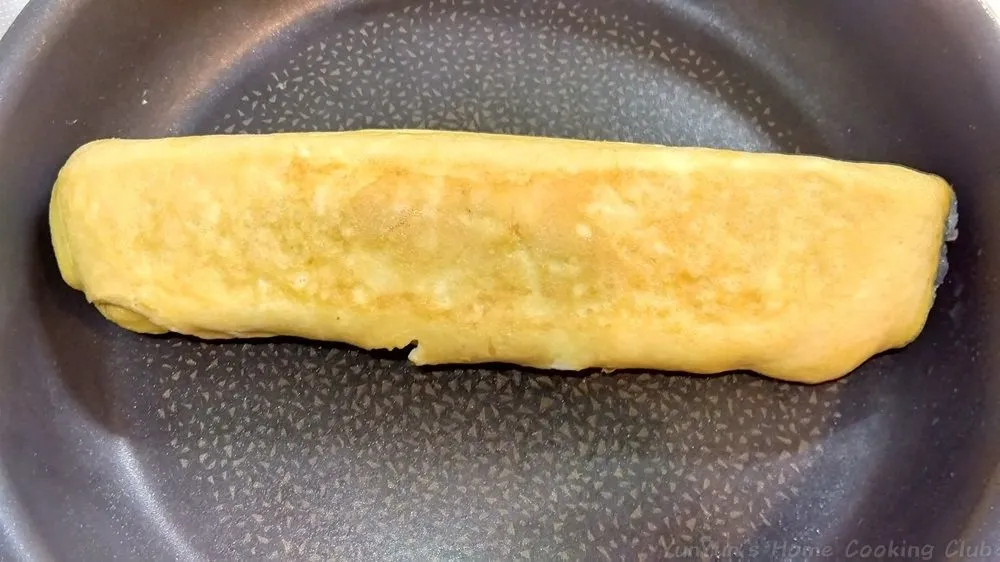 フライパンの中央に置かれた完成しただし巻き卵。