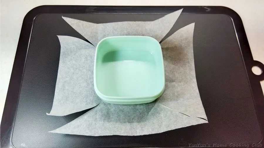 四隅をカットしたクッキングペーパーの上におかれた容器。