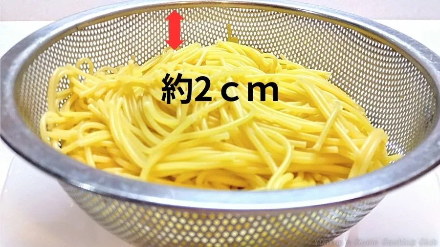 茹でたパスタ300gがざるいっぱいに入っているのを横から見た画像。
