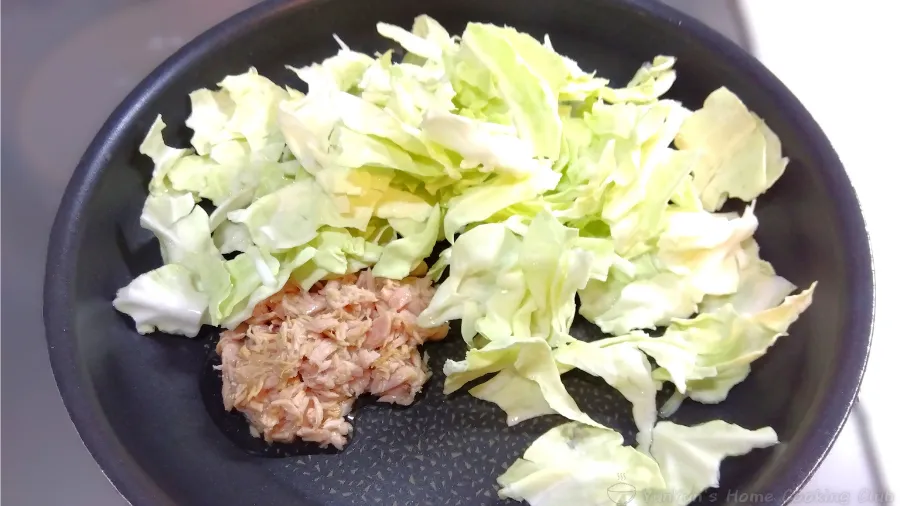 フライパンでツナ缶(油ごと)とちぎったキャベツを入れた様子